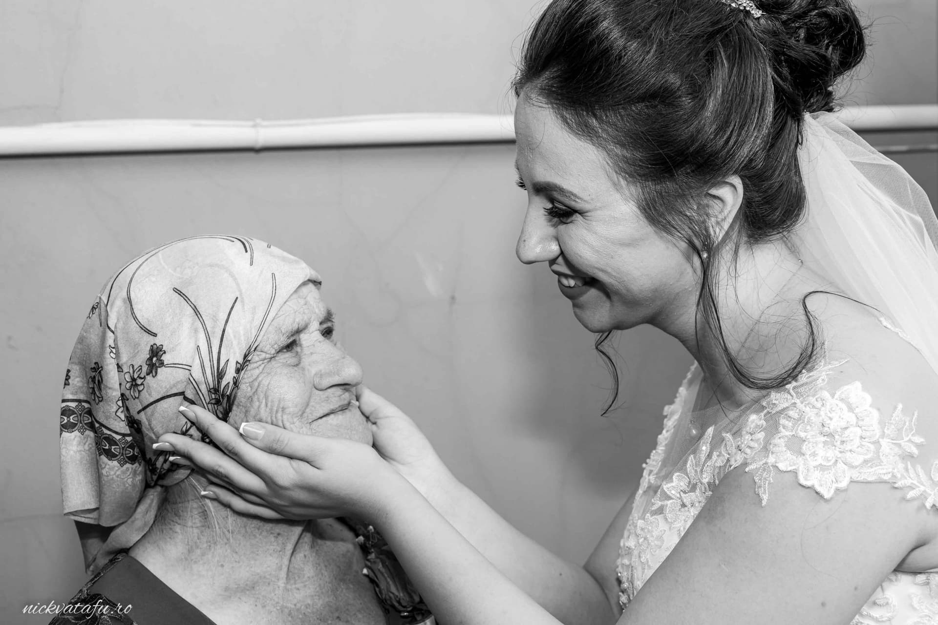 Mireasă zâmbitoare, îmbrățișând o bunică emoționată, captură plină de dragoste în ziua nunții.