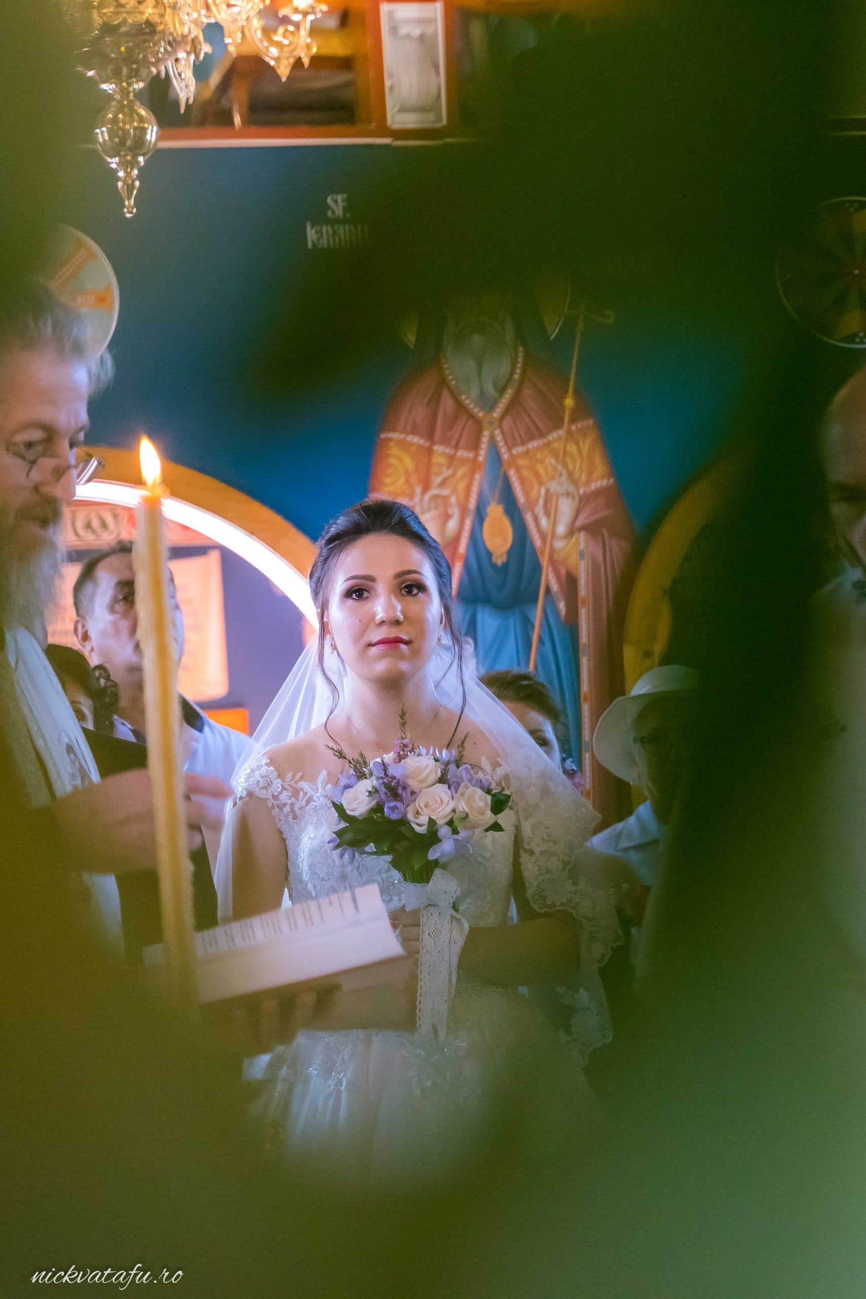 Mireasă emoționată, cu buchet în mână, la ceremonie religioasă, detalii nuntă într-o biserică din Pitești.