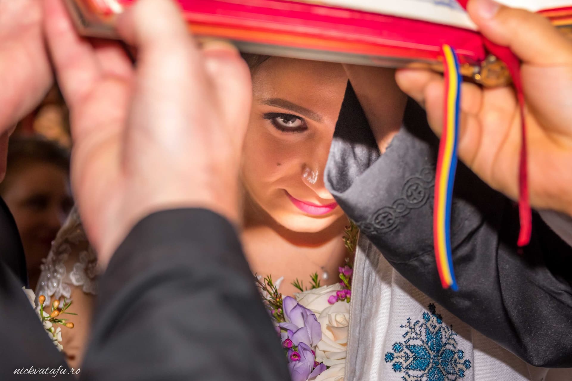 Mireasă emoționată, surprinsă în momentul tradițional al ceremoniei, detalii nuntă vibrante și pline de culoare.