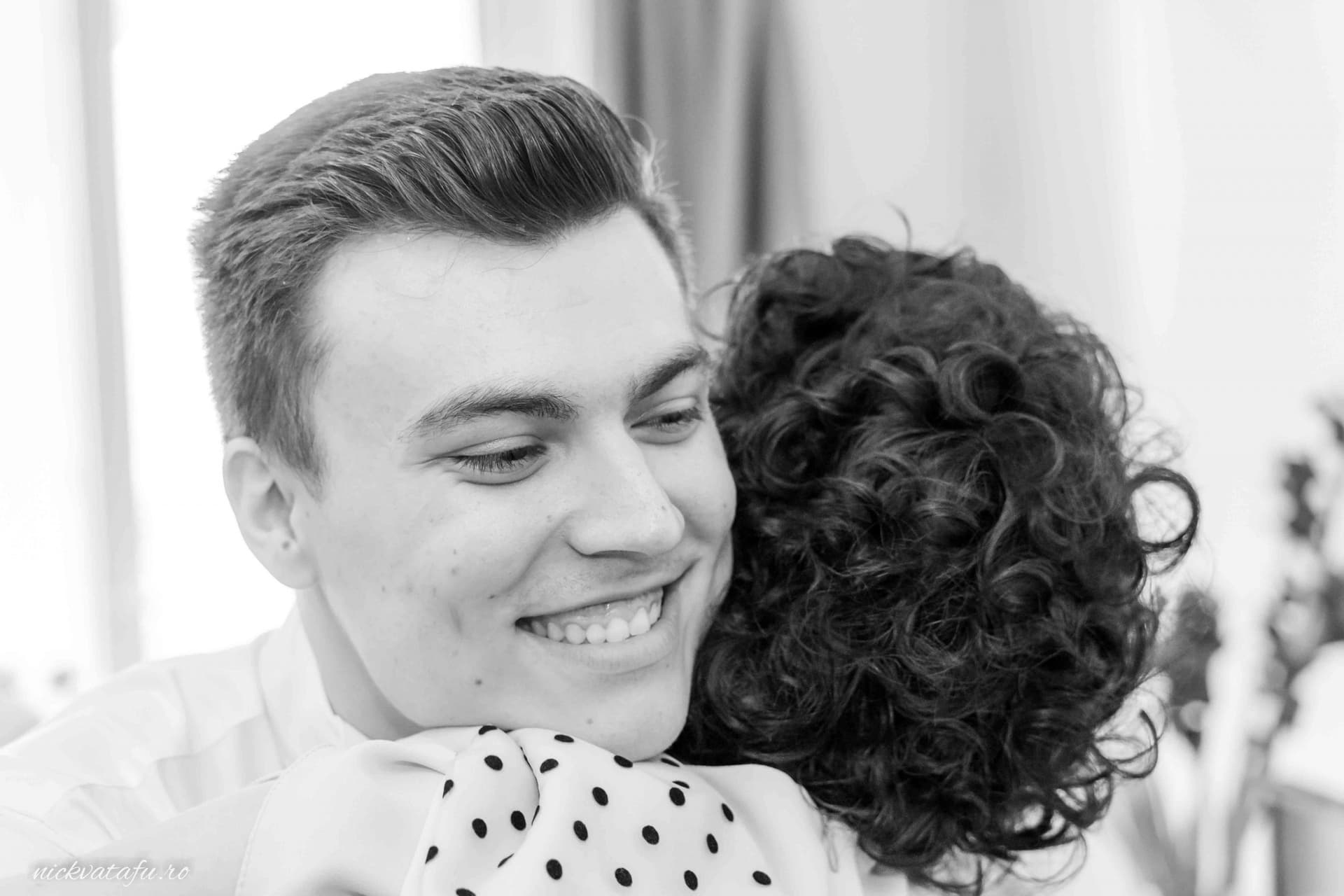 Îmbrățișare plină de bucurie între doi prieteni, capturată în cadrul unui eveniment special, fotografie emoționantă.