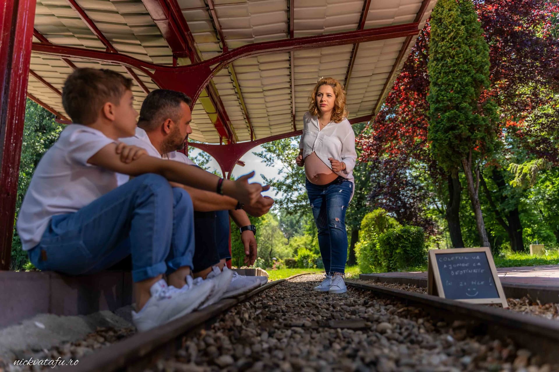 Familie fericită la o stație de tren, așteptând cu emoție un nou început, fotografie de botez în Pitești.