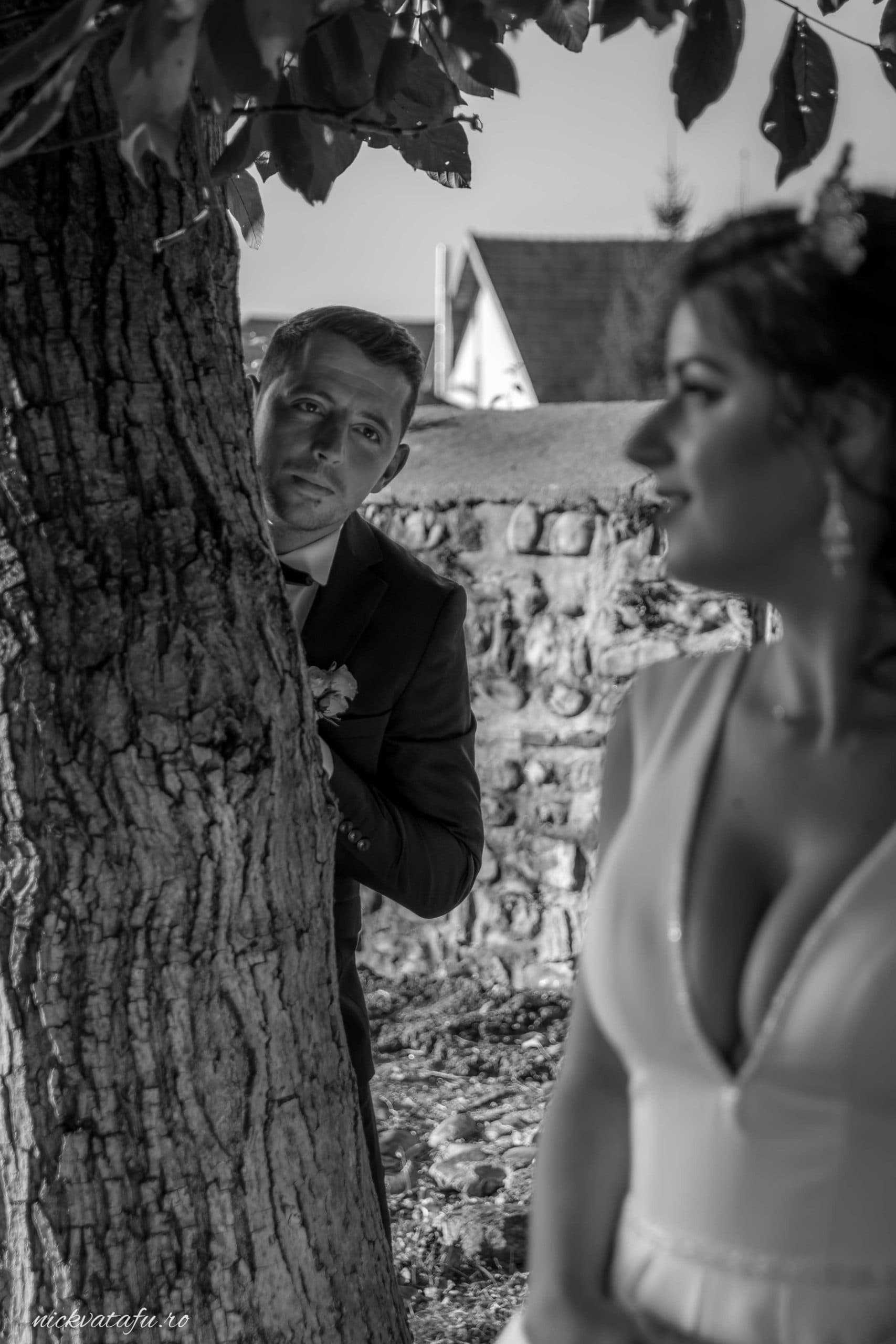 Mire și mireasă într-un moment de intimitate, zâmbete și emoție, fotografie de nuntă într-un decor natural.