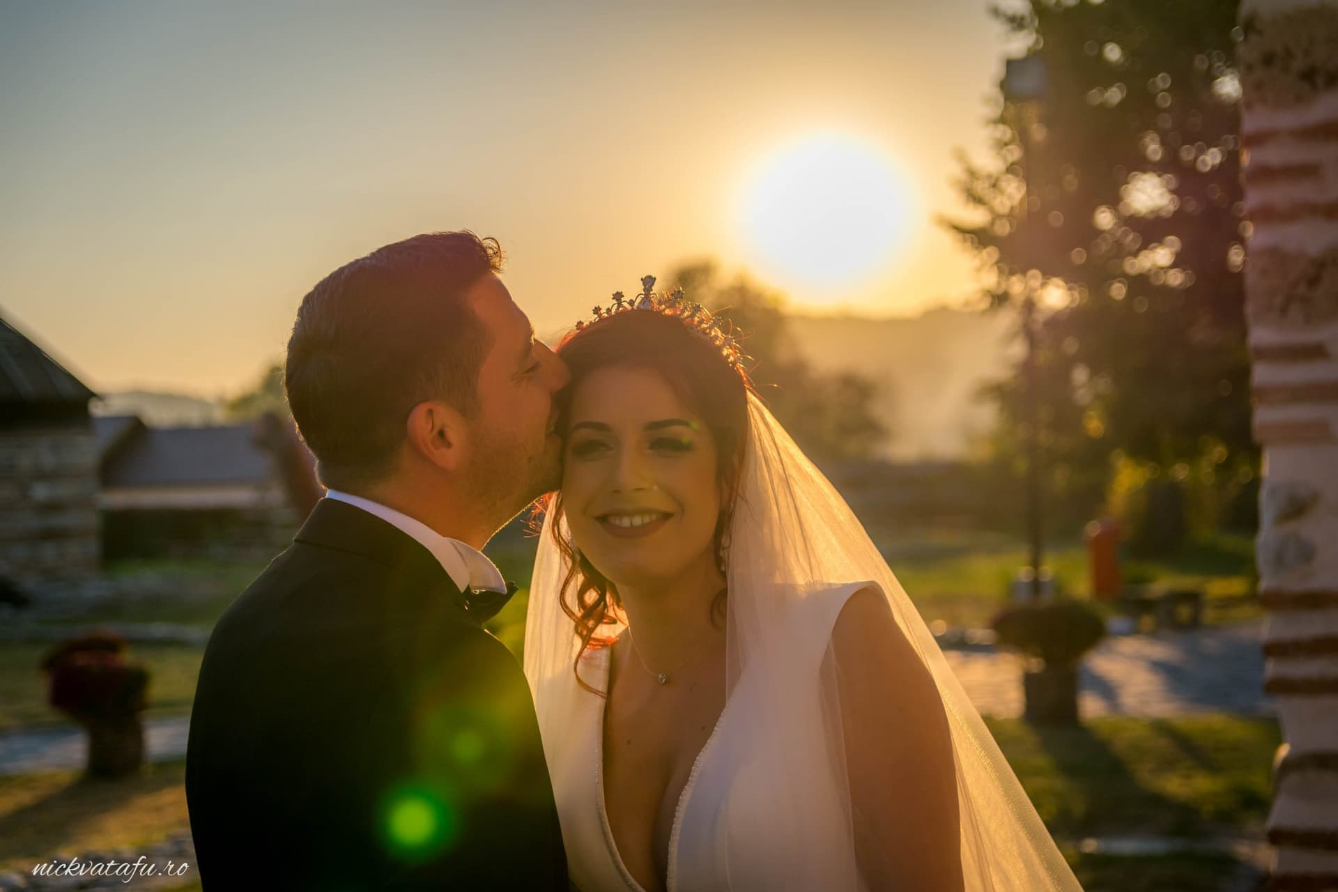 Mire și mireasă zâmbind cu emoție la apus, fotografie de nuntă plină de romantism și lumină caldă.