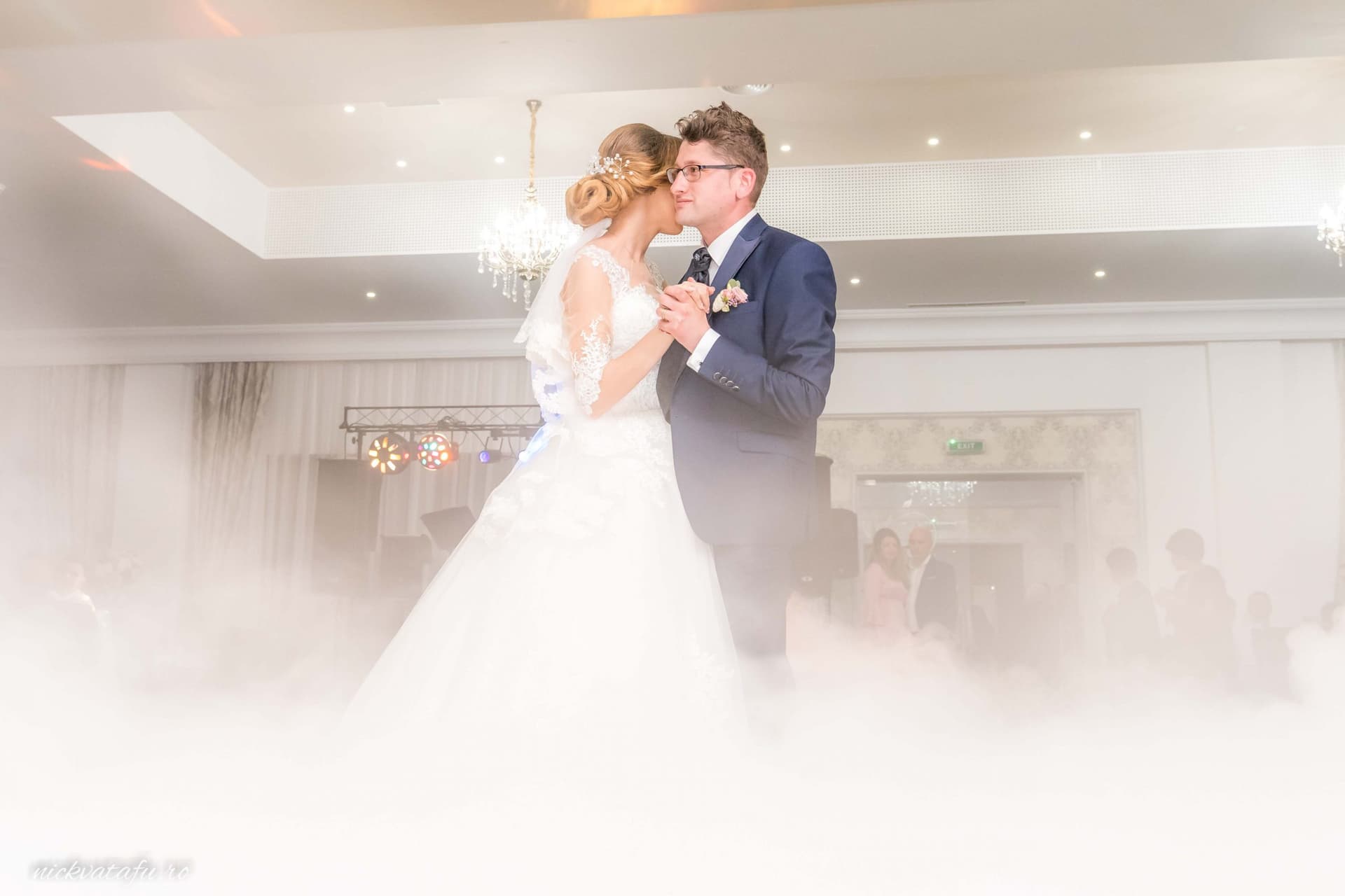 Mire și mireasă dansând romantic în mijlocul unei atmosfere de neuitat, fotografie nuntă elegantă.