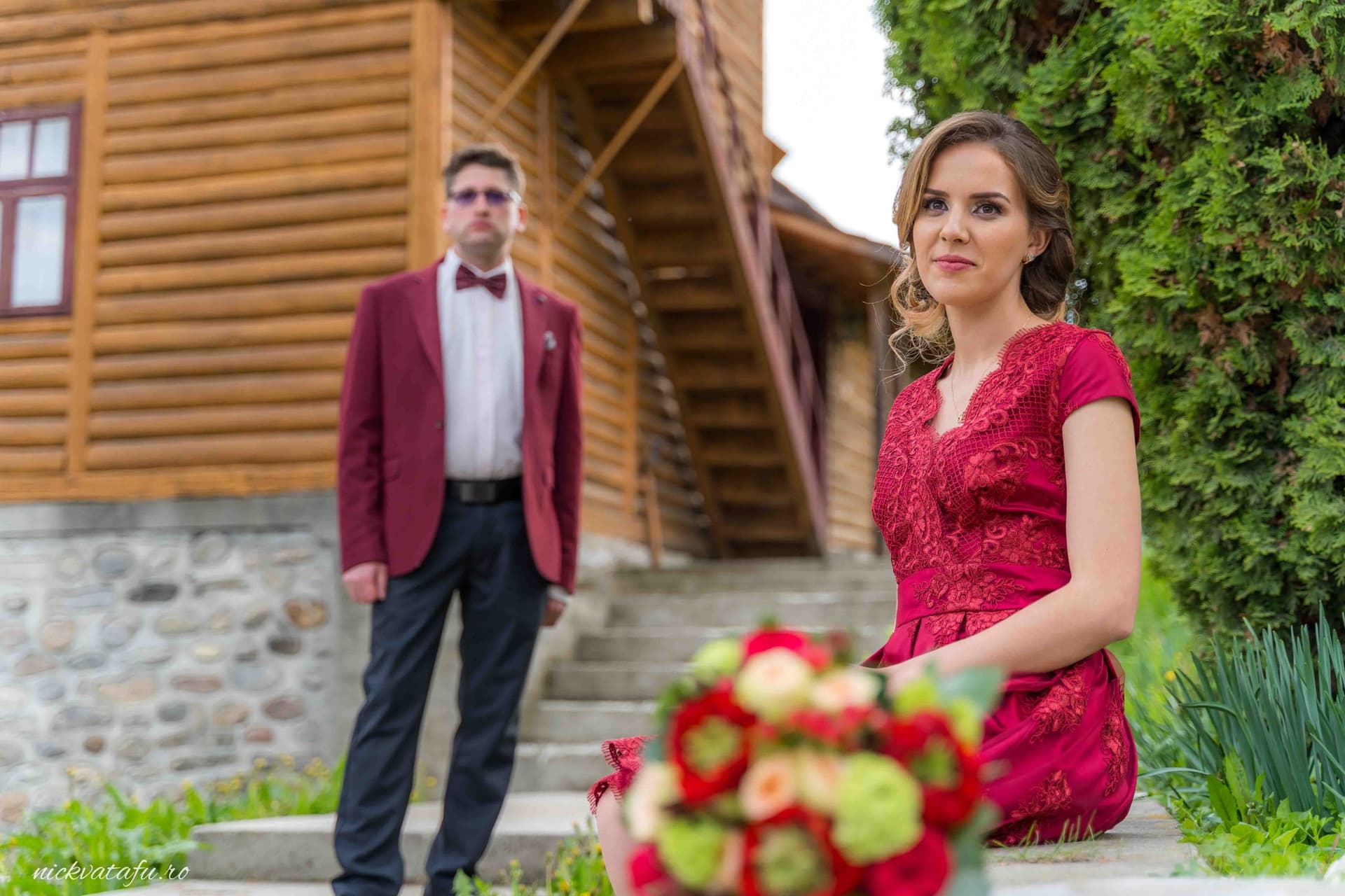 Mireasă elegantă cu buchet de flori, privind emoționant spre mire, într-o atmosferă romantică la o nuntă.
