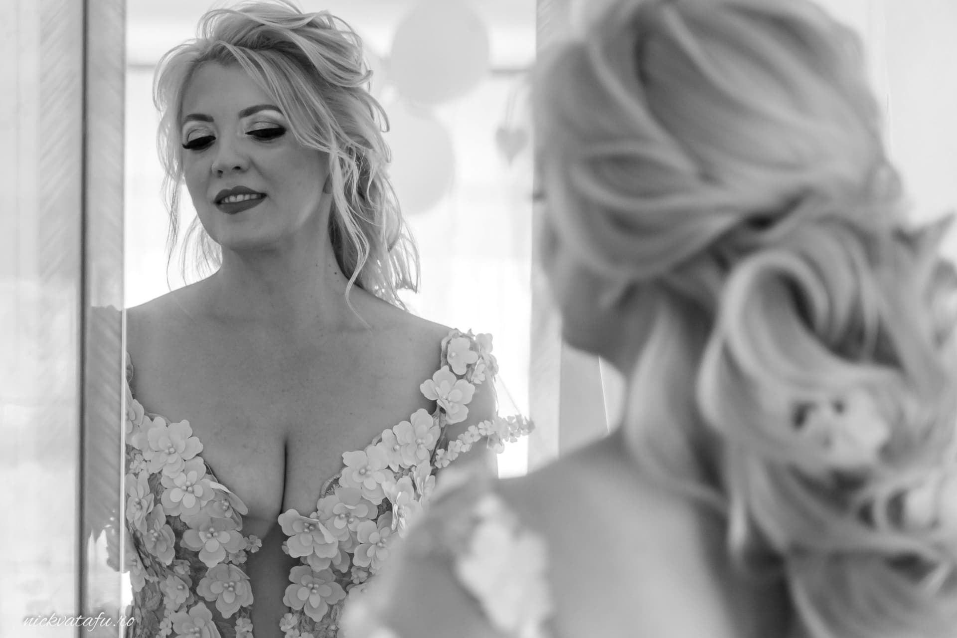 Mireasă admirându-se în oglindă, emoție și eleganță înainte de ceremonia de nuntă.