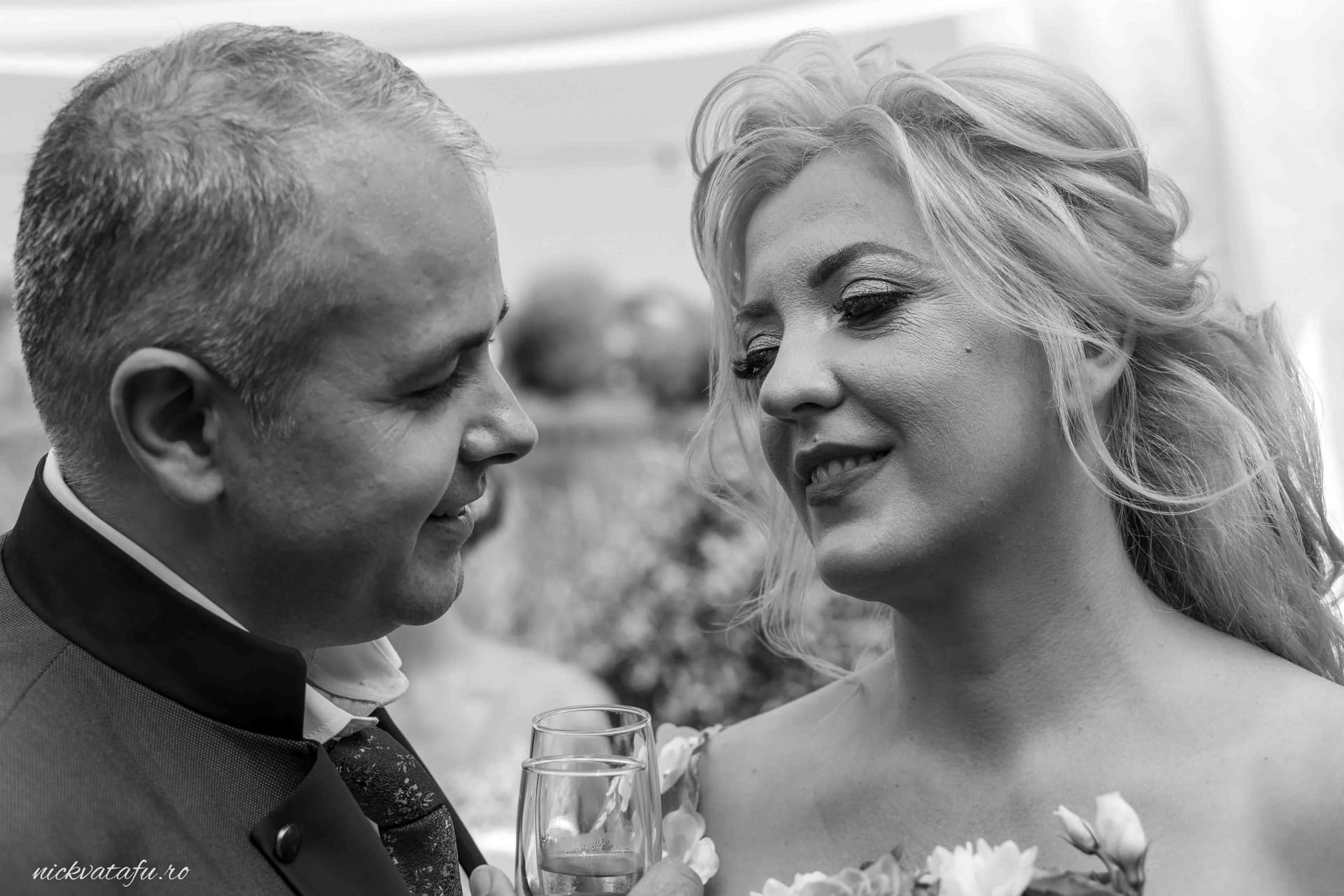 Mire și mireasă privindu-se cu dragoste, emoție și bucurie, într-o fotografie de nuntă elegantă.