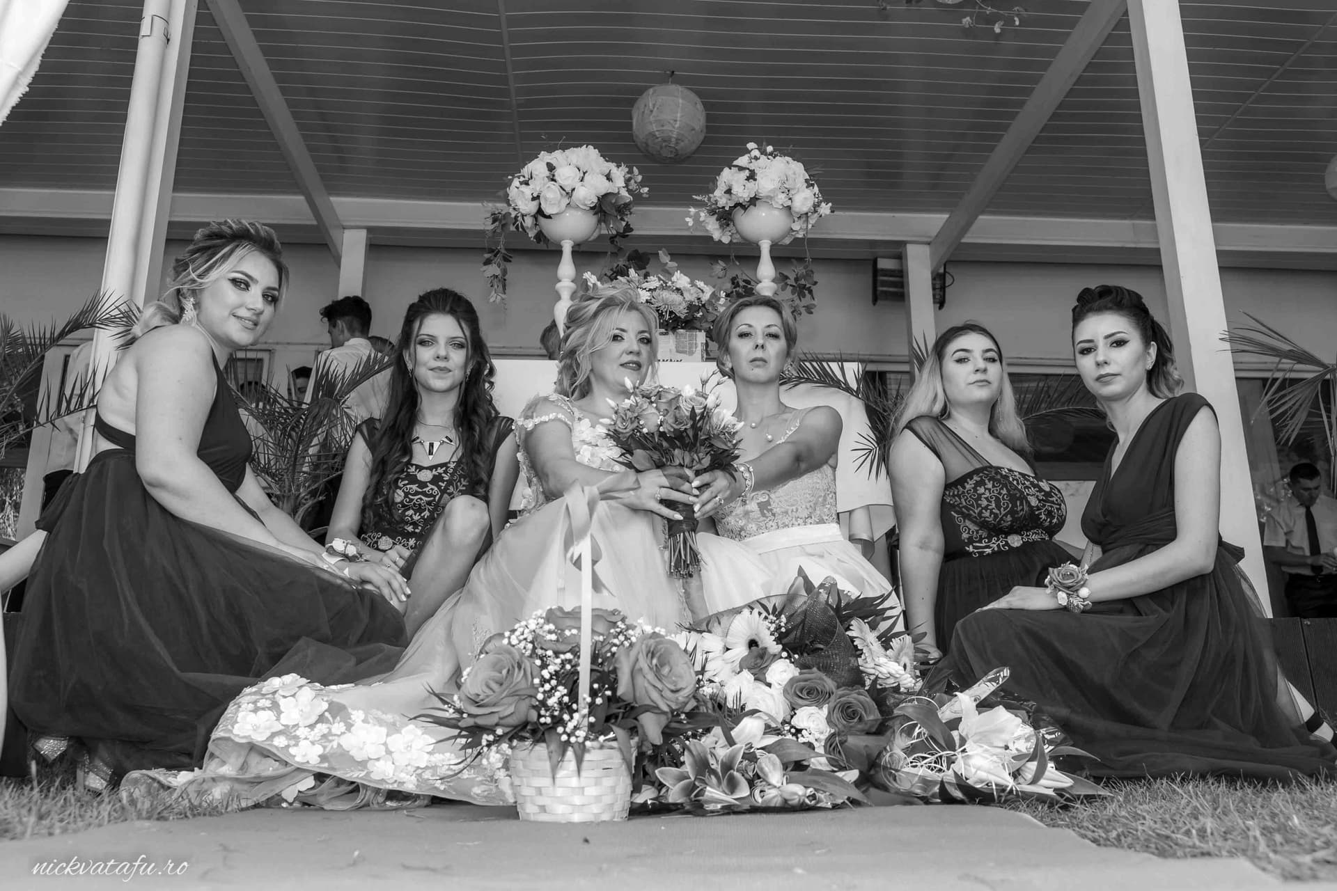 Mireasă elegantă înconjurată de domnițe de onoare, capturând emoția unui moment special la un botez în Pitești.