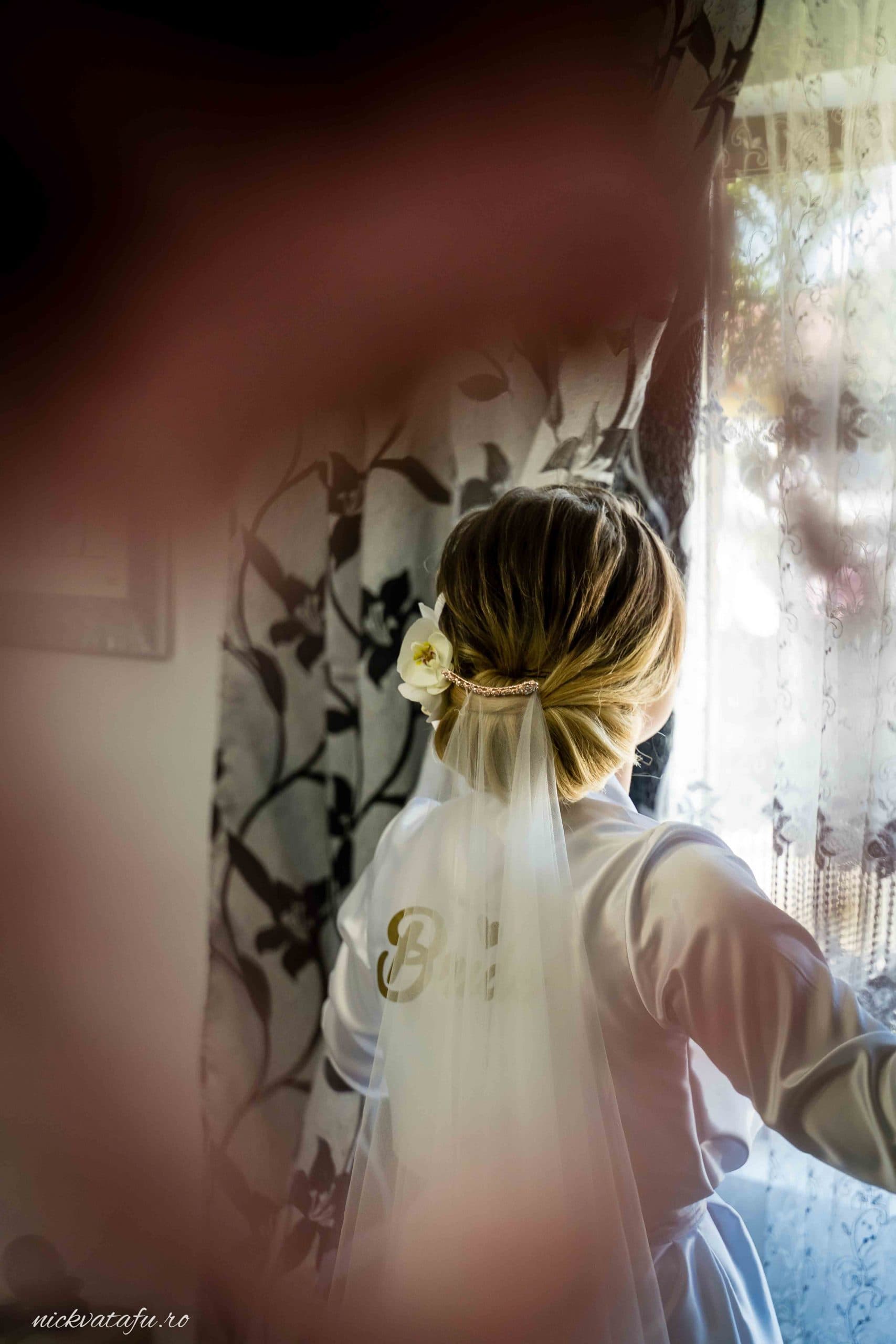 Mireasă pregătindu-se pentru marele moment, emoție și detalii elegante într-o fotografie de nuntă.