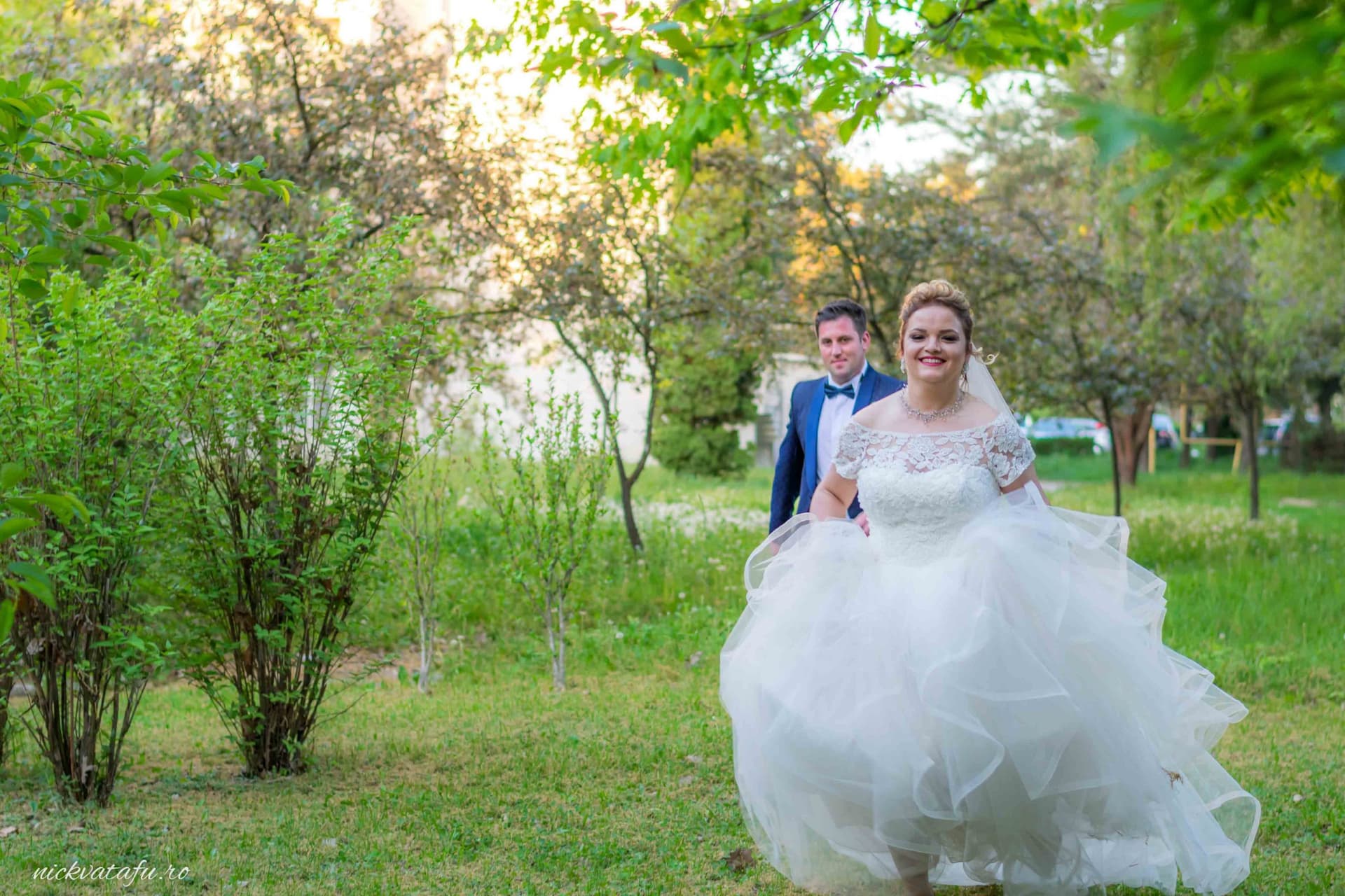 Mire și mireasă zâmbind în natură, fotografia de nuntă surprinde o atmosferă romantică și emoționantă.