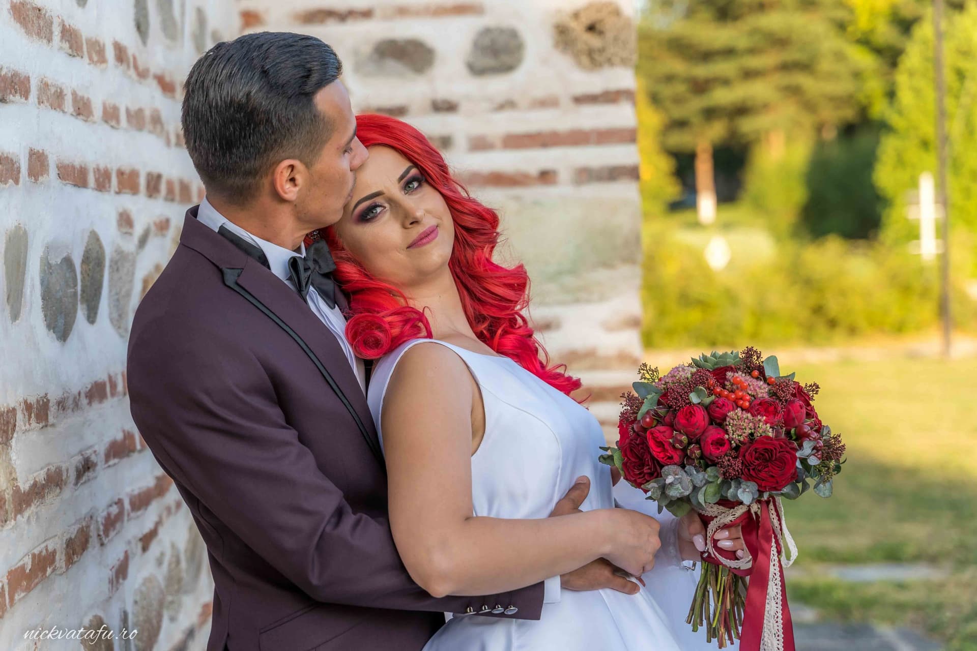 Mire și mireasă zâmbind, îmbrățișați cu emoție, fotografia de nuntă surprinsă într-un decor natural.