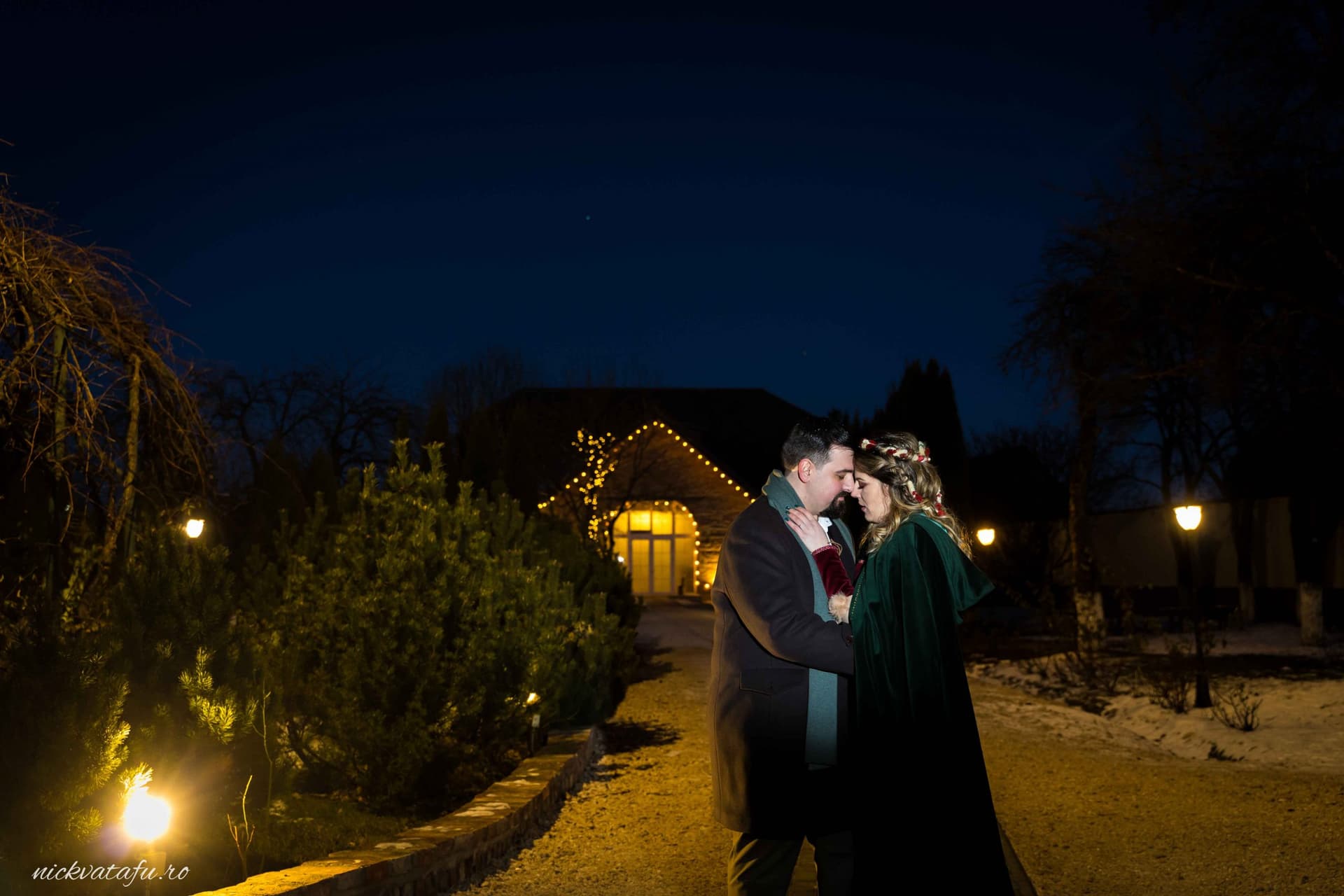 Mire și mireasă se sărută sub lumini calde, fotografie de nuntă romantică, atmosfera nocturnă de poveste.