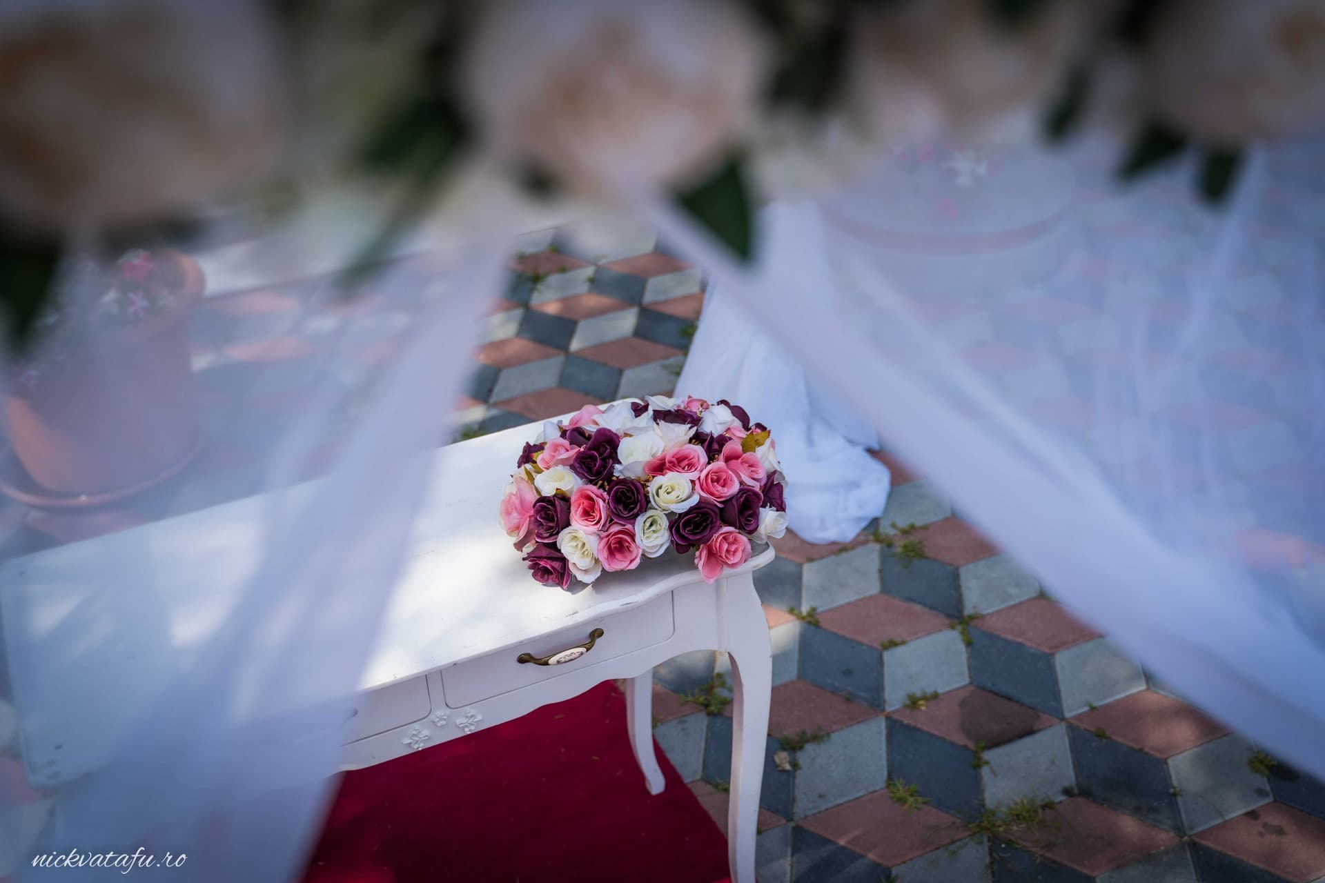 Buchet de flori elegant pe o masă albă, detalii nuntă într-un decor rafinat, plin de emoție.