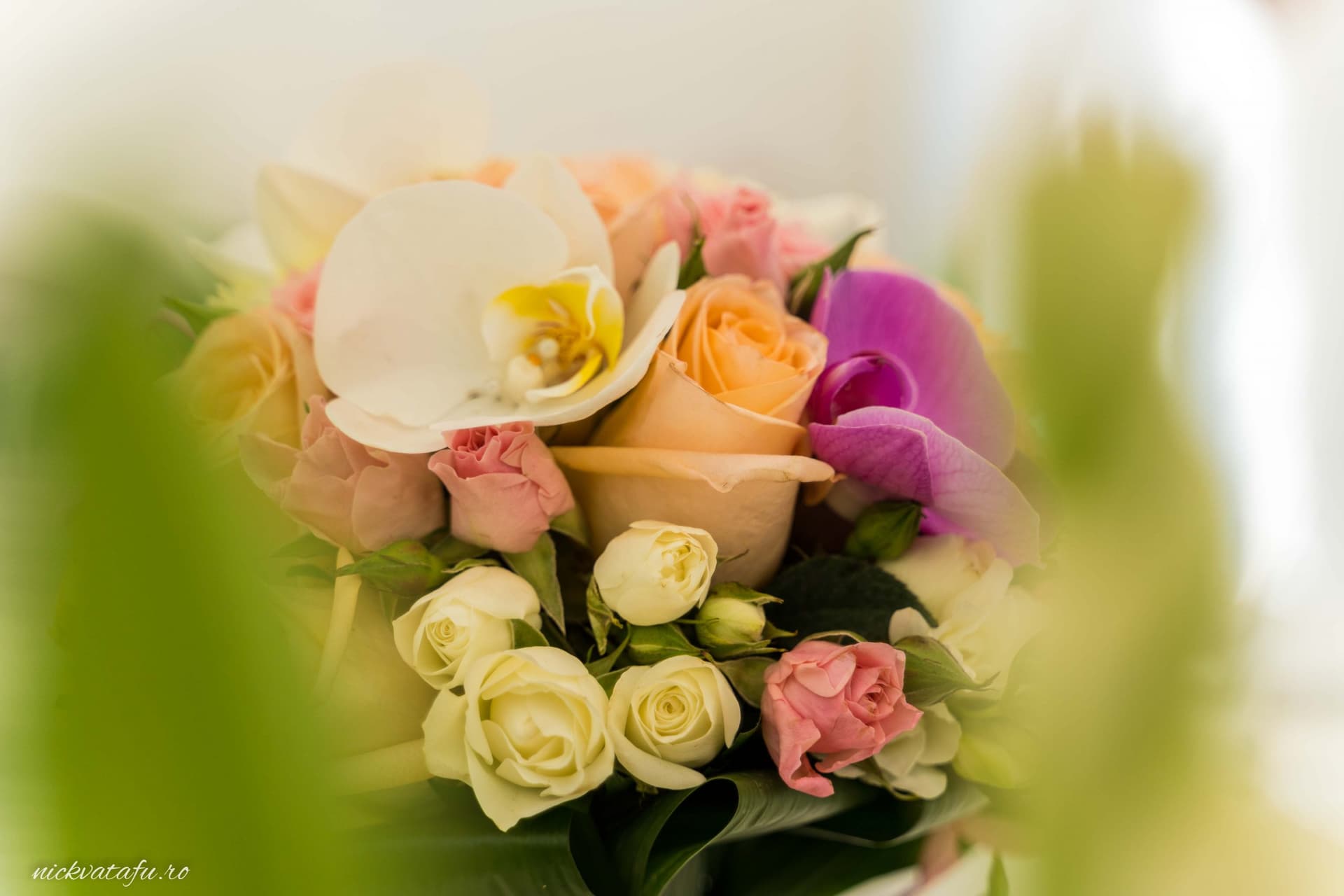 Buchet de flori delicate, cu trandafiri și orhidee, detalii elegante pentru o fotografie de nuntă.