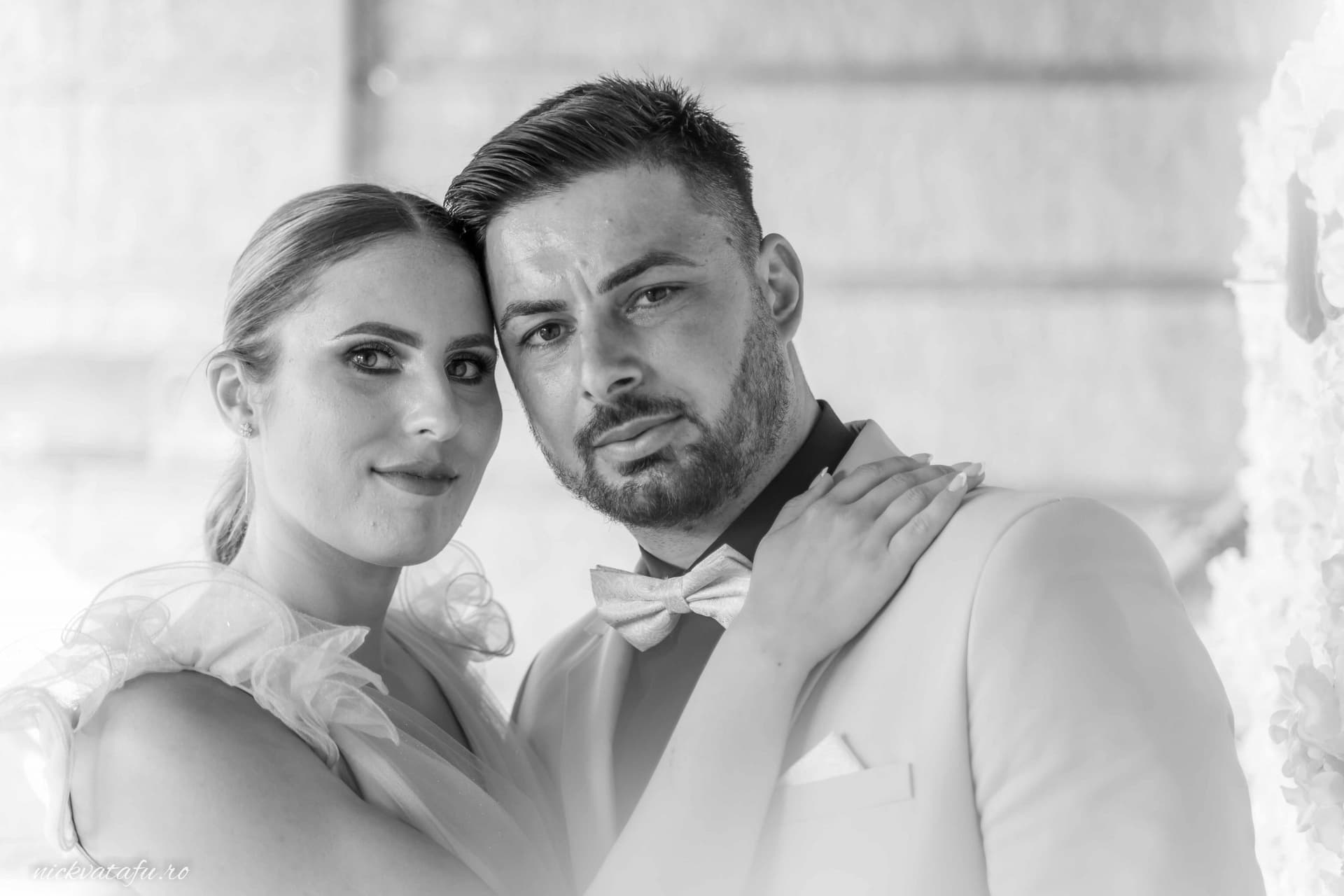 Mire și mireasă într-un moment intim, surprinși într-o fotografie de nuntă alb-negru, emanând emoție și eleganță.