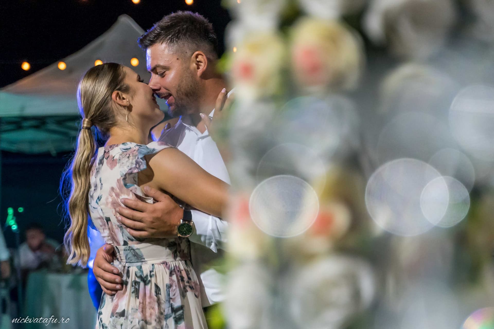 Mire și mireasă zâmbind și îmbrățișându-se în lumina blândă a serii, fotografie de nuntă plină de emoție.