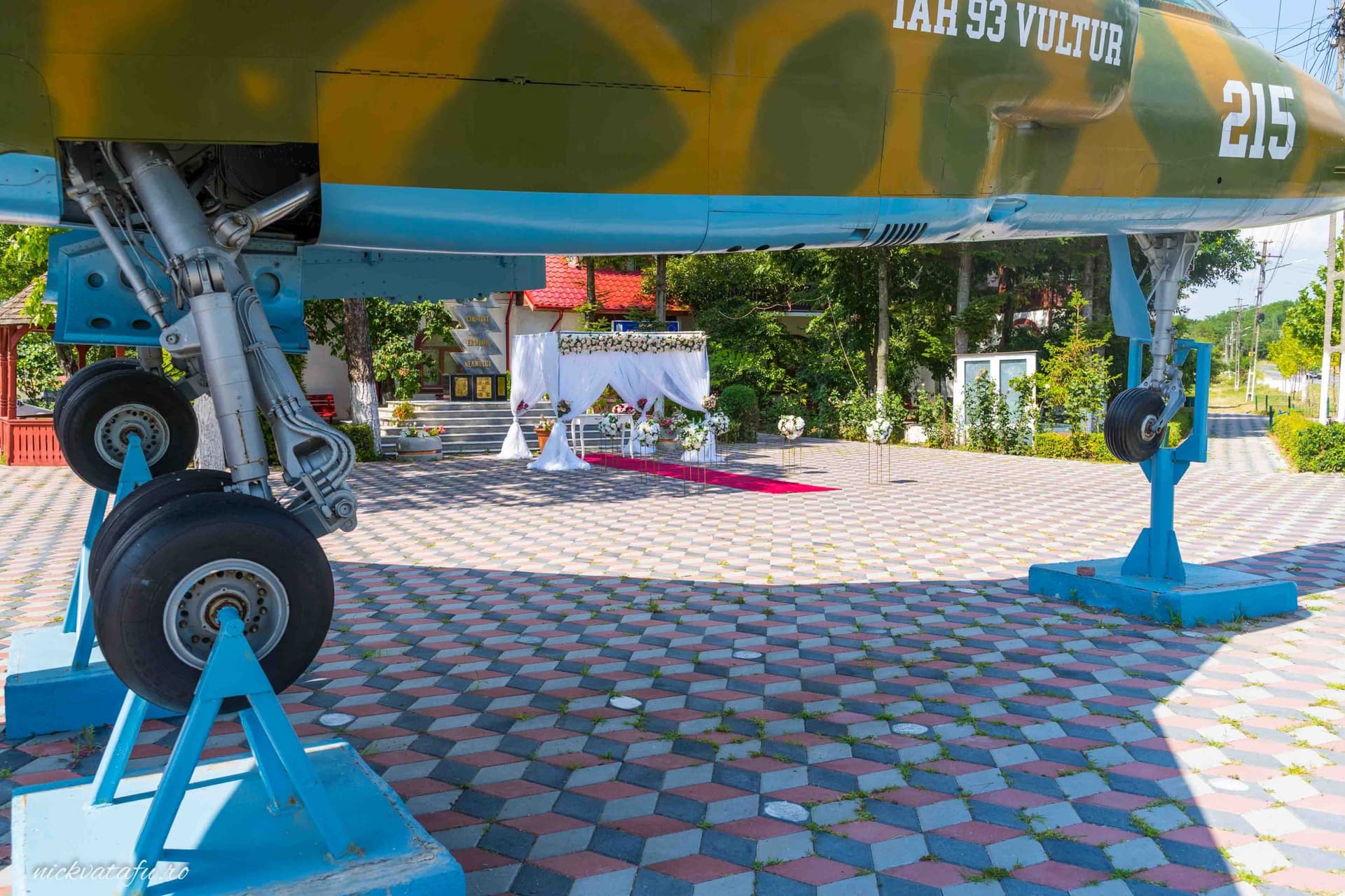 Spațiu decorat pentru un eveniment festiv, cu detalii colorate pe podea și fundal pregătit pentru o ceremonie.