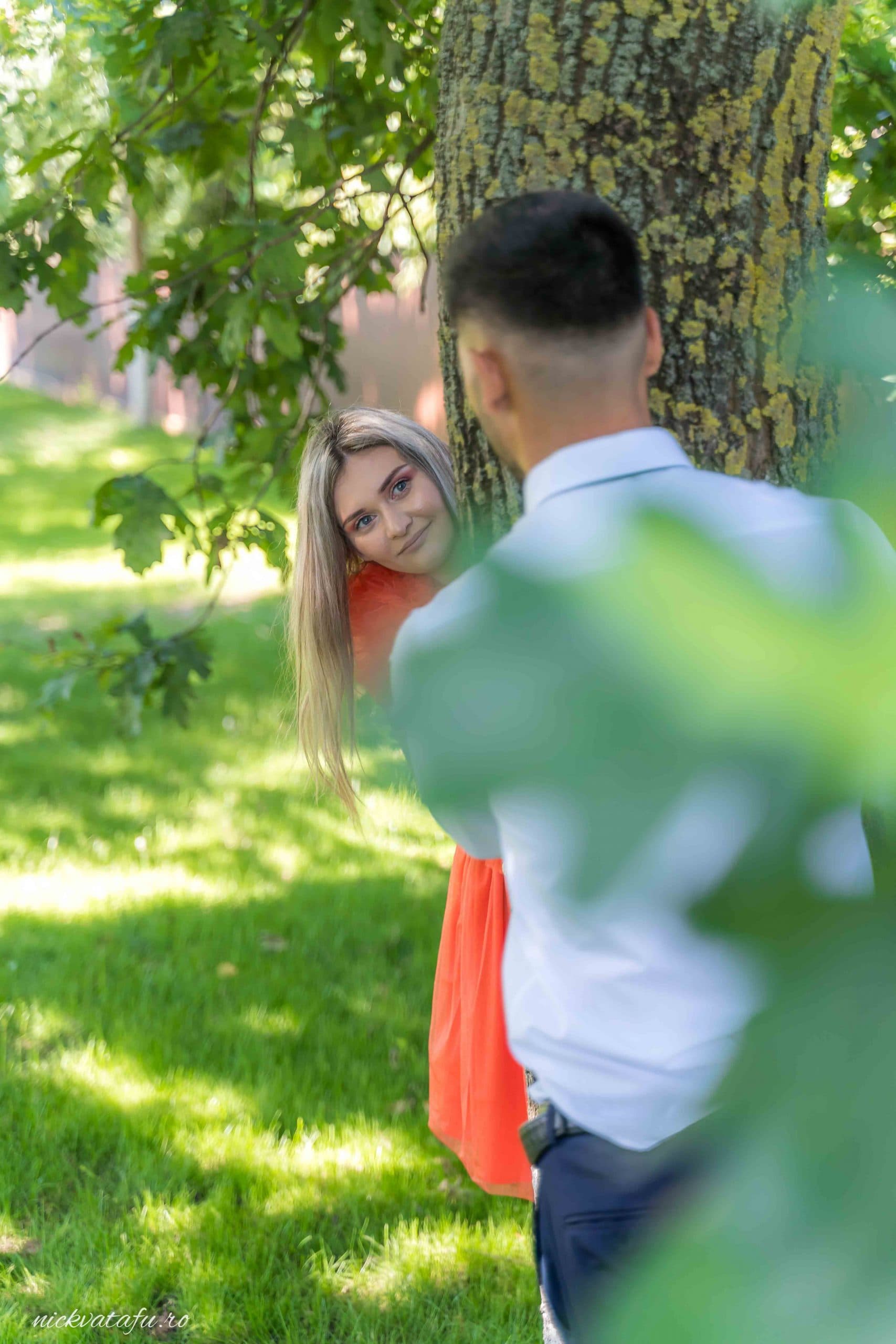 Îmbrățișare jucăușă între un cuplu fericit, înconjurați de natură, fotografie de nuntă plină de emoție.