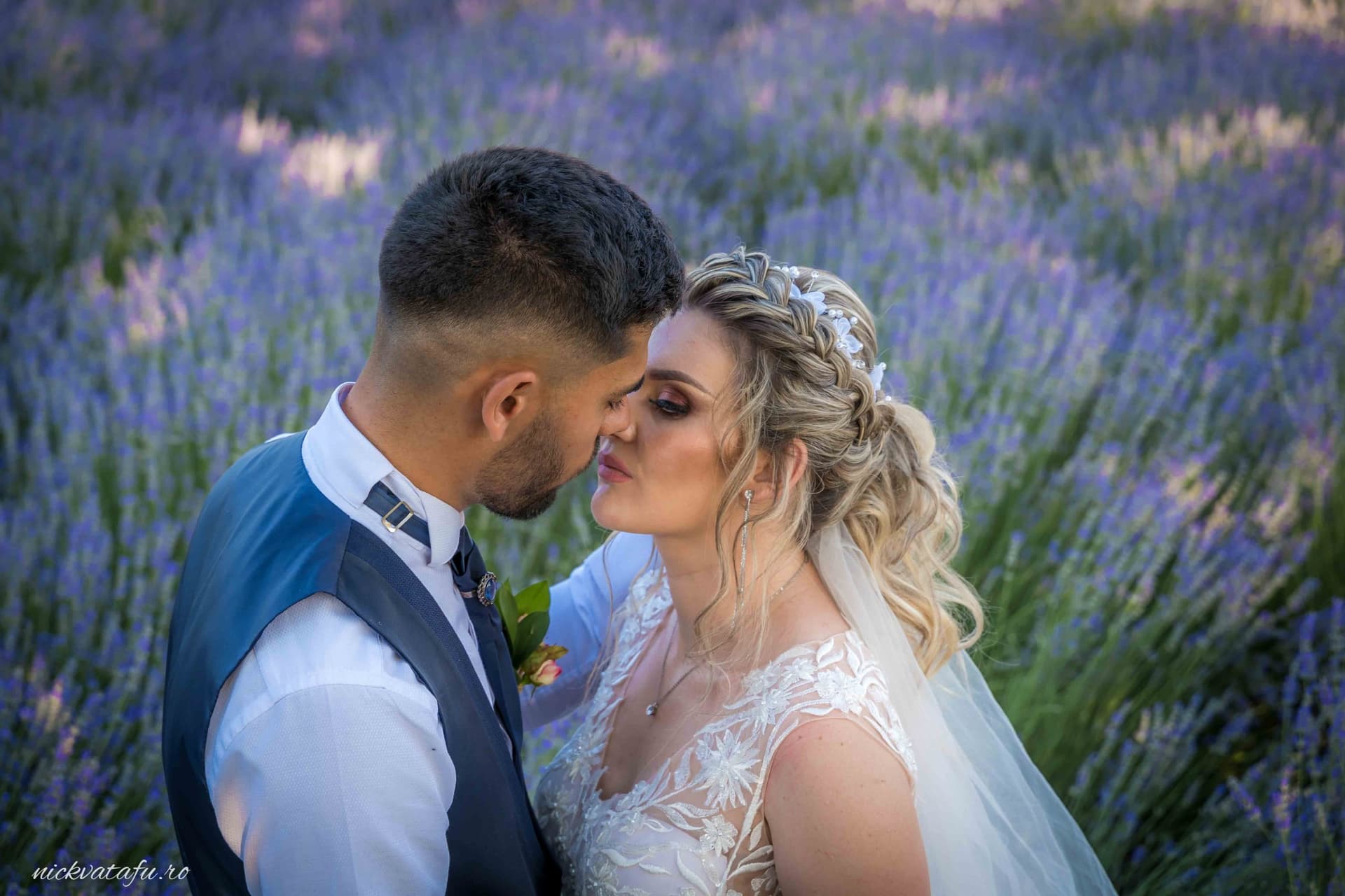 Mire și mireasă împărtășind un sărut plin de emoție, înconjurați de lavandă, fotografie de nuntă romantică.
