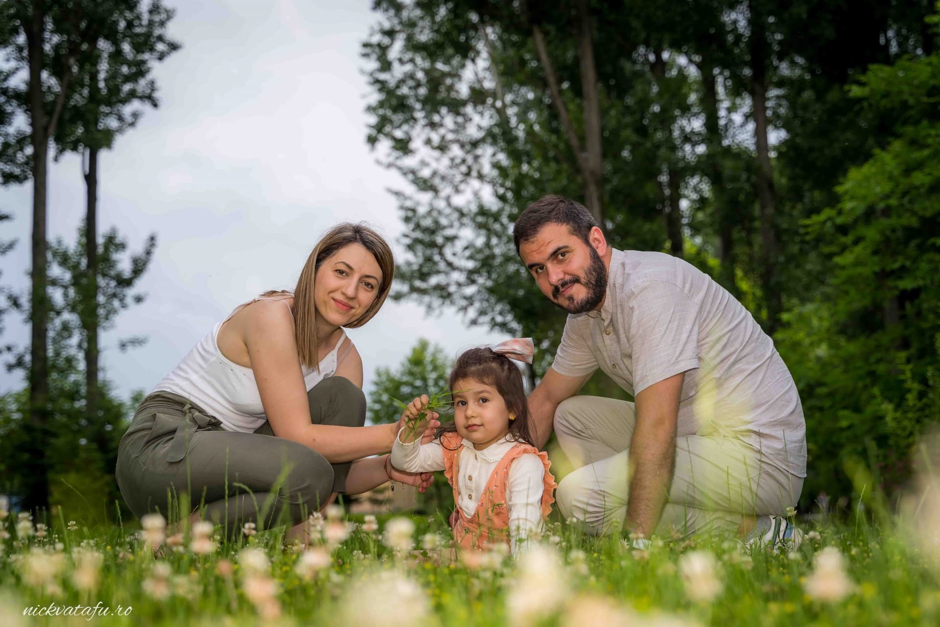 Familie fericită petrecând timp în natură, zâmbete și emoție în mijlocul florilor, fotografie de familie.