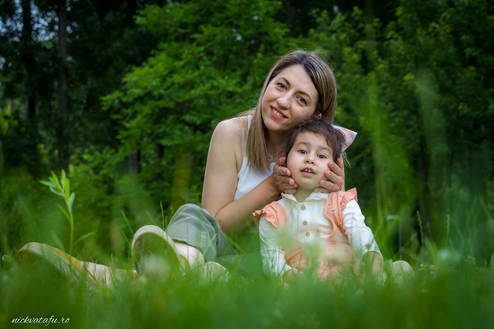 Mamă și copil zâmbind fericiți în natură, surprinși într-un moment plin de emoție și bucurie.