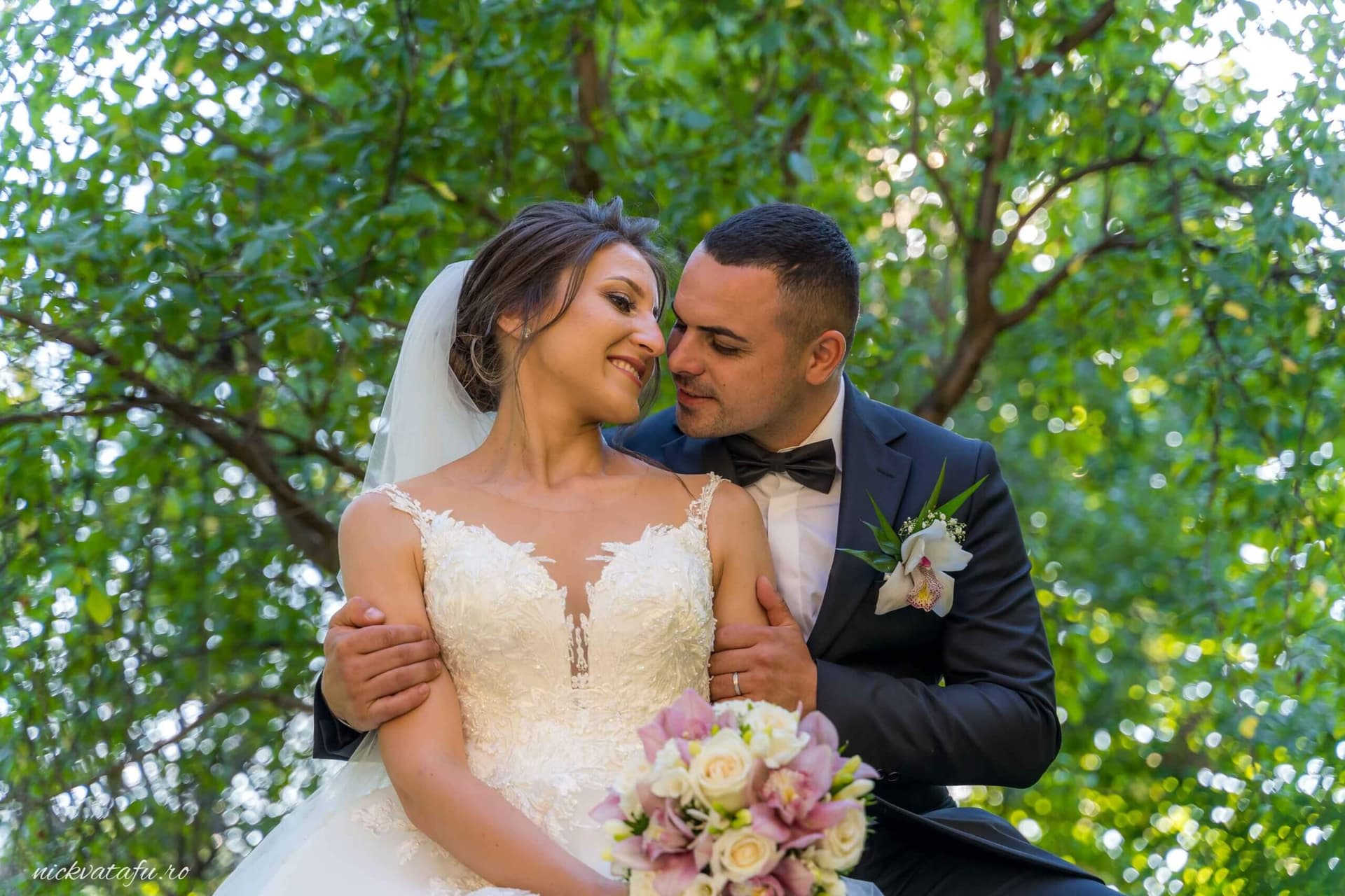 Mire și mireasă zâmbind fericiți, înconjurați de natură, fotografie elegantă de nuntă cu emoție autentică.