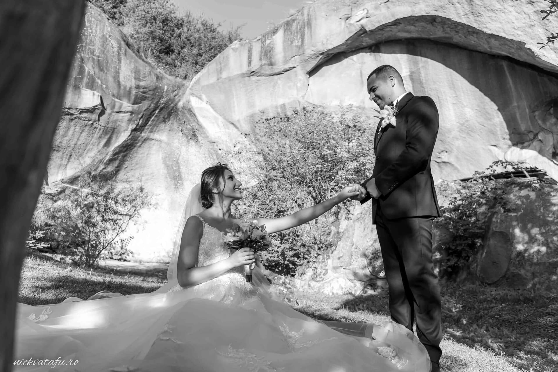 Mire și mireasă într-un moment romantic, ținându-se de mână, fotografie de nuntă în peisaj urban.