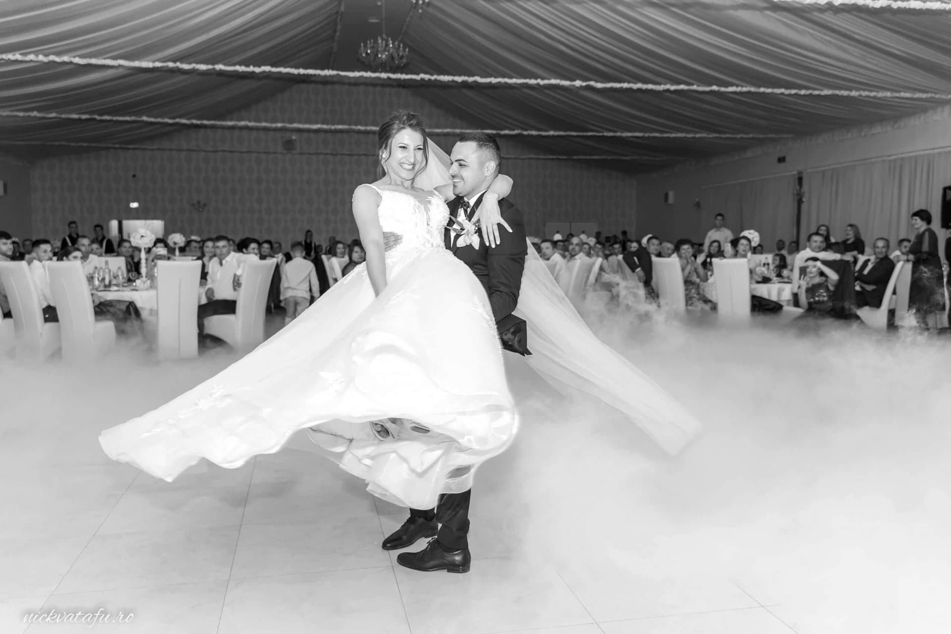 Mire și mireasă dansând cu bucurie în mijlocul petrecerii, fotografie de nuntă plină de emoție și energie.