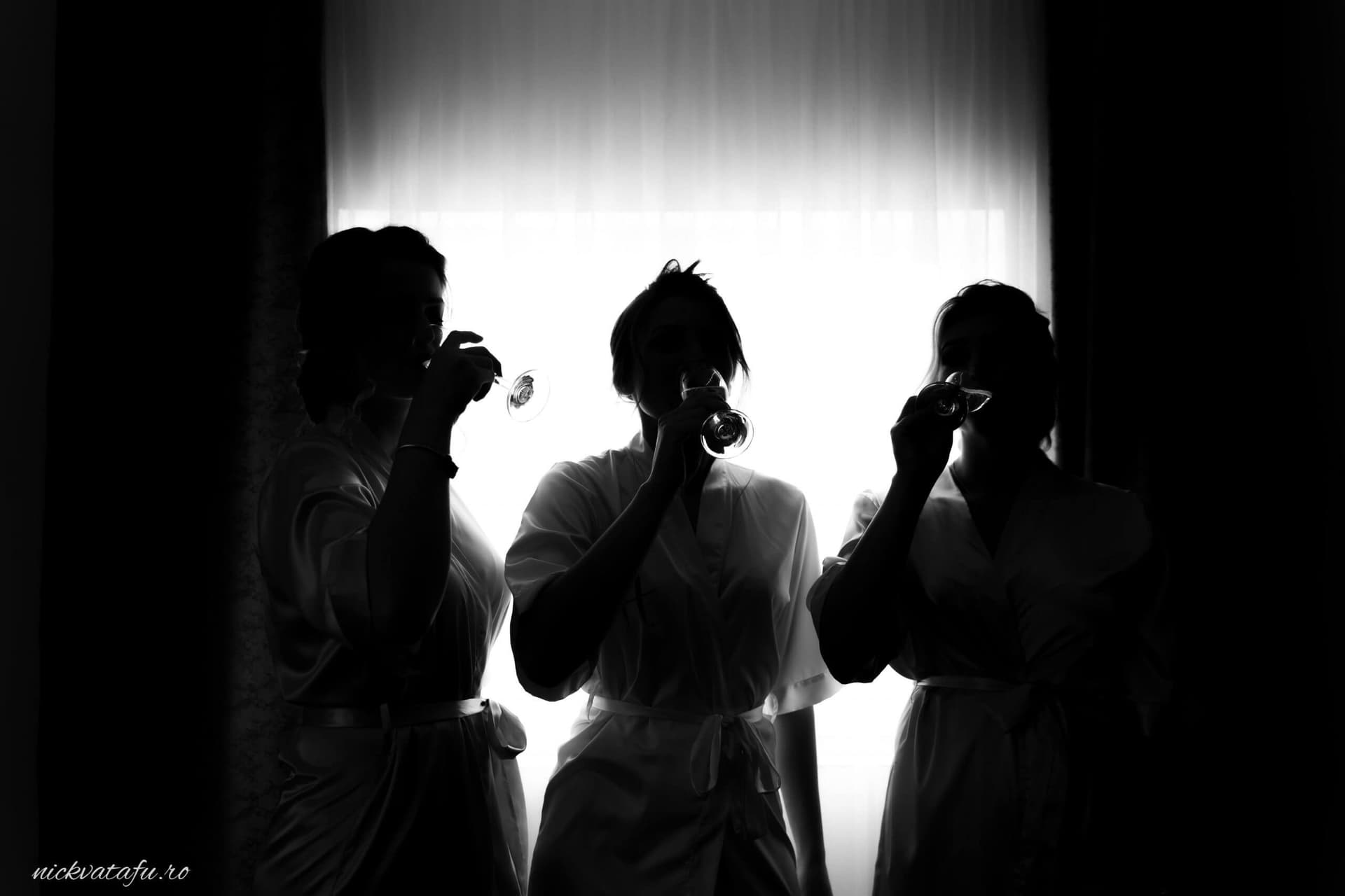 Miresele se pregătesc cu emoție, savurând un moment de relaxare înainte de nuntă, fotografie elegantă în lumina naturală.