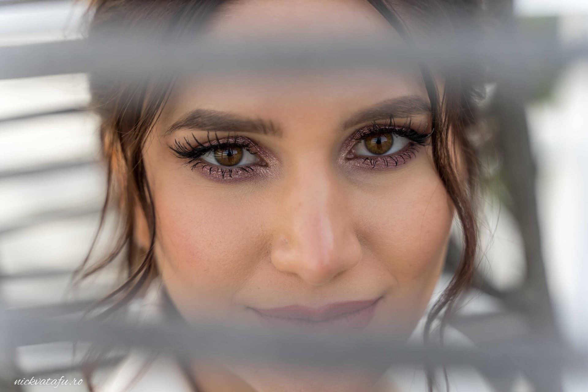 Privire intensă a unei mirese, cu detalii elegante ale machiajului, surprinsă în fotografia de nuntă.