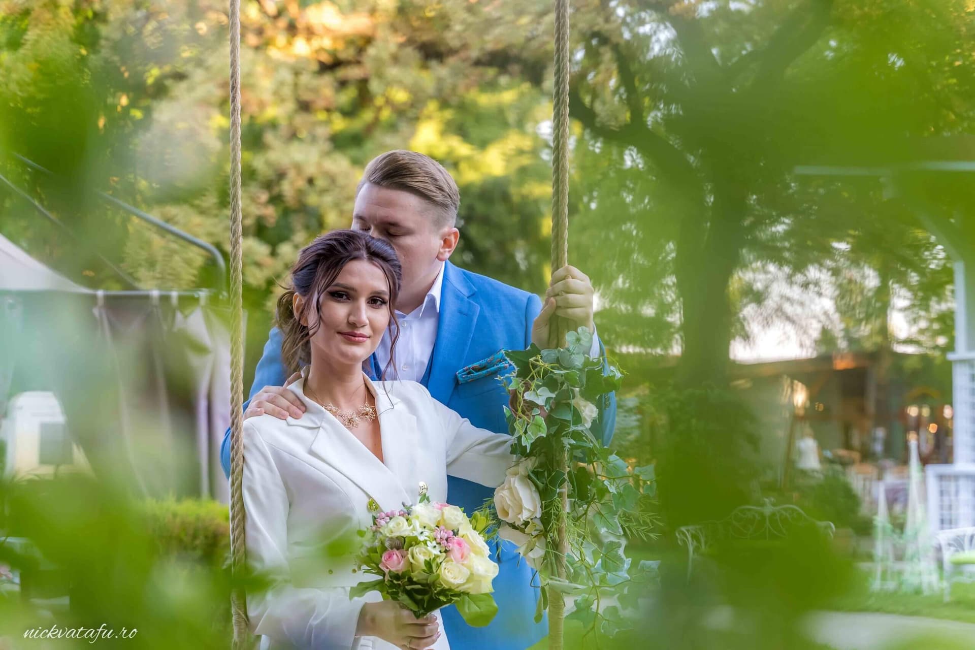 Mire și mireasă pe o leagăn în natură, zâmbete pline de emoție, fotografie de nuntă elegantă.