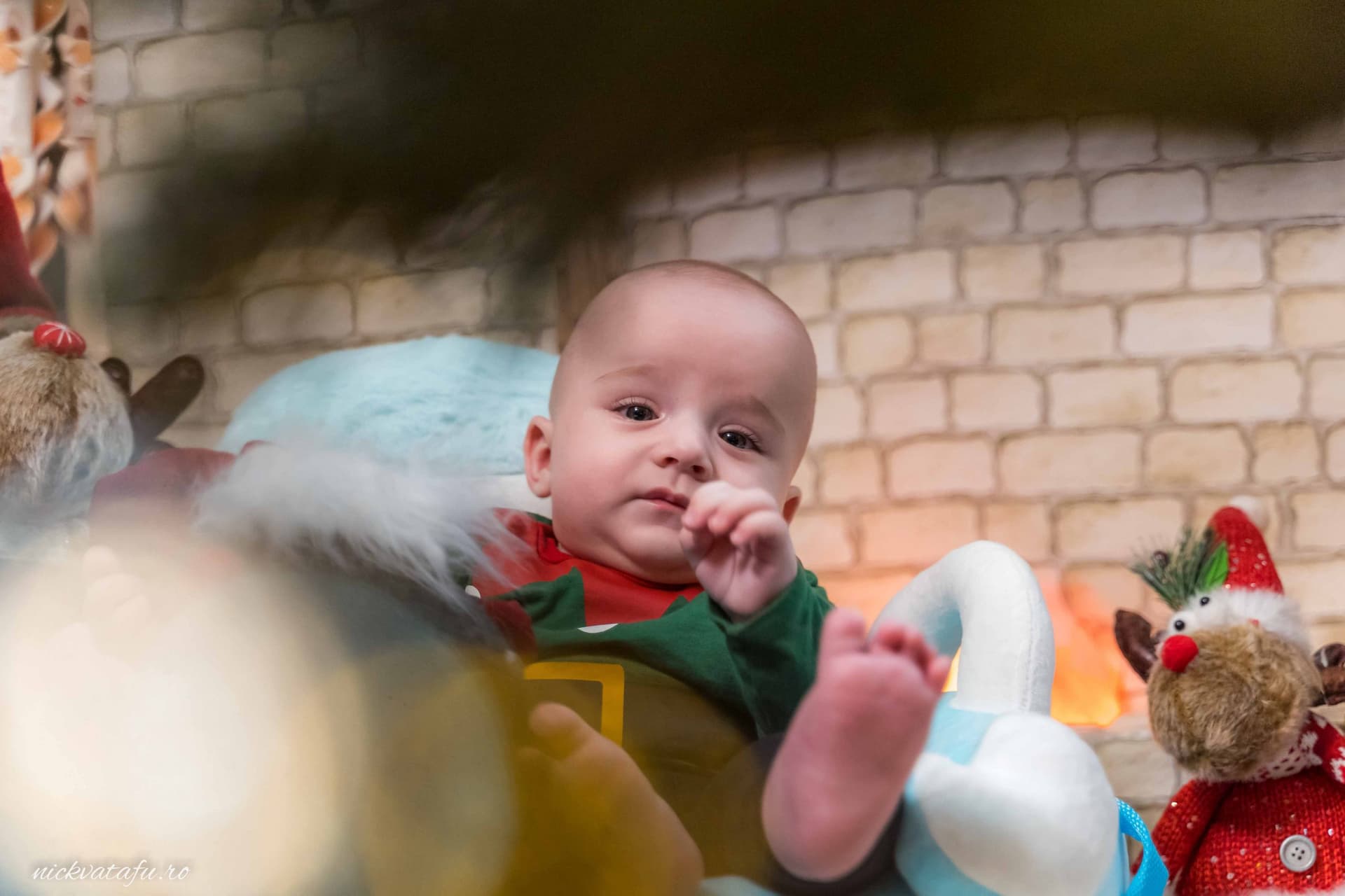 Bebeluș zâmbitor în decor de sărbătoare, înconjurat de jucării, fotografia de botez surprinde emoția momentului.