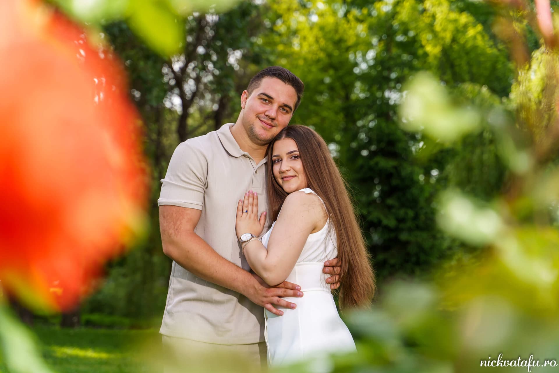 Îmbrățișare romantică între un cuplu fericit, într-un cadru natural, fotografie de nuntă plină de emoție.